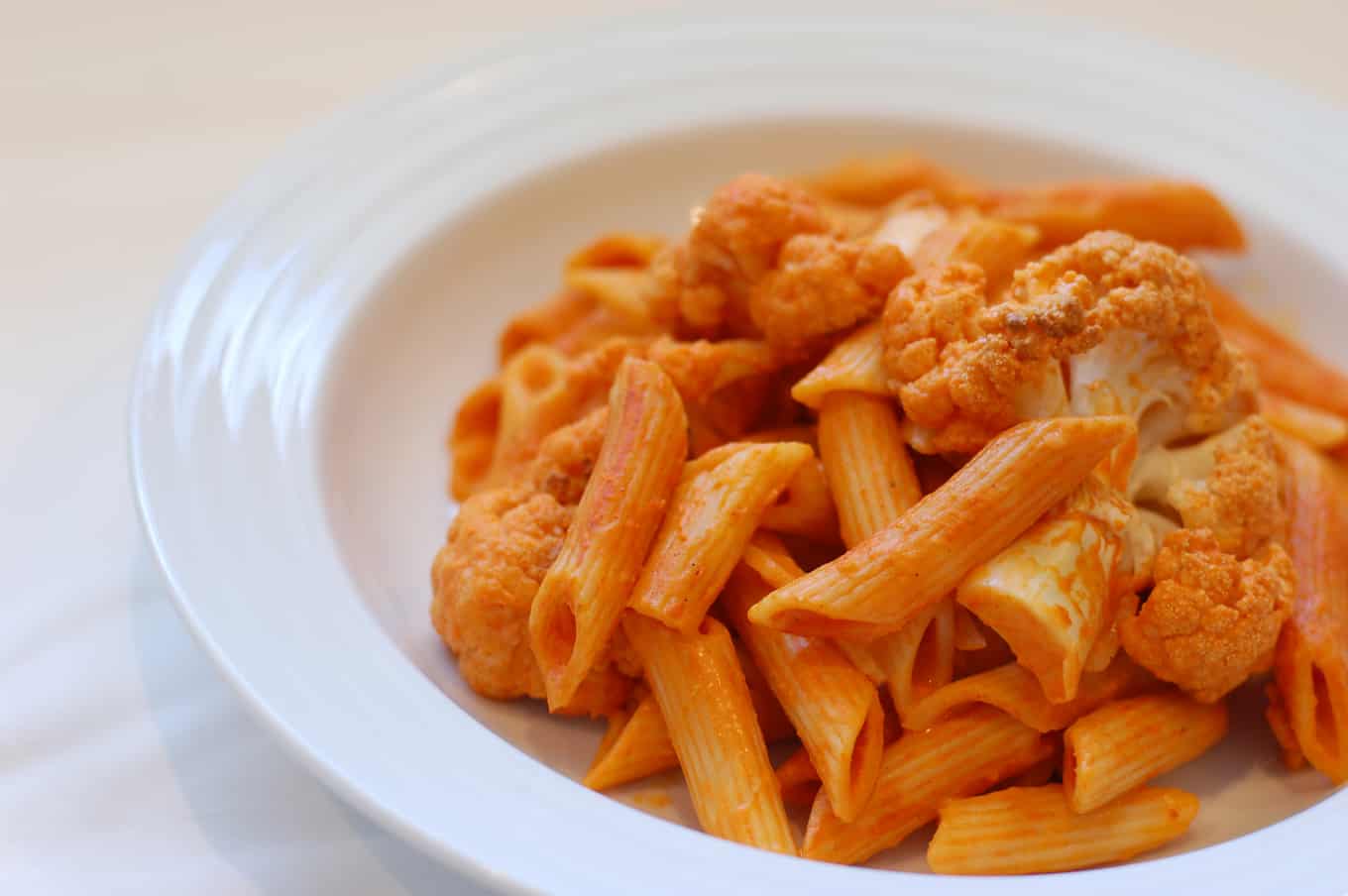 vegan red pepper cream sauce with pasta in a bowl.