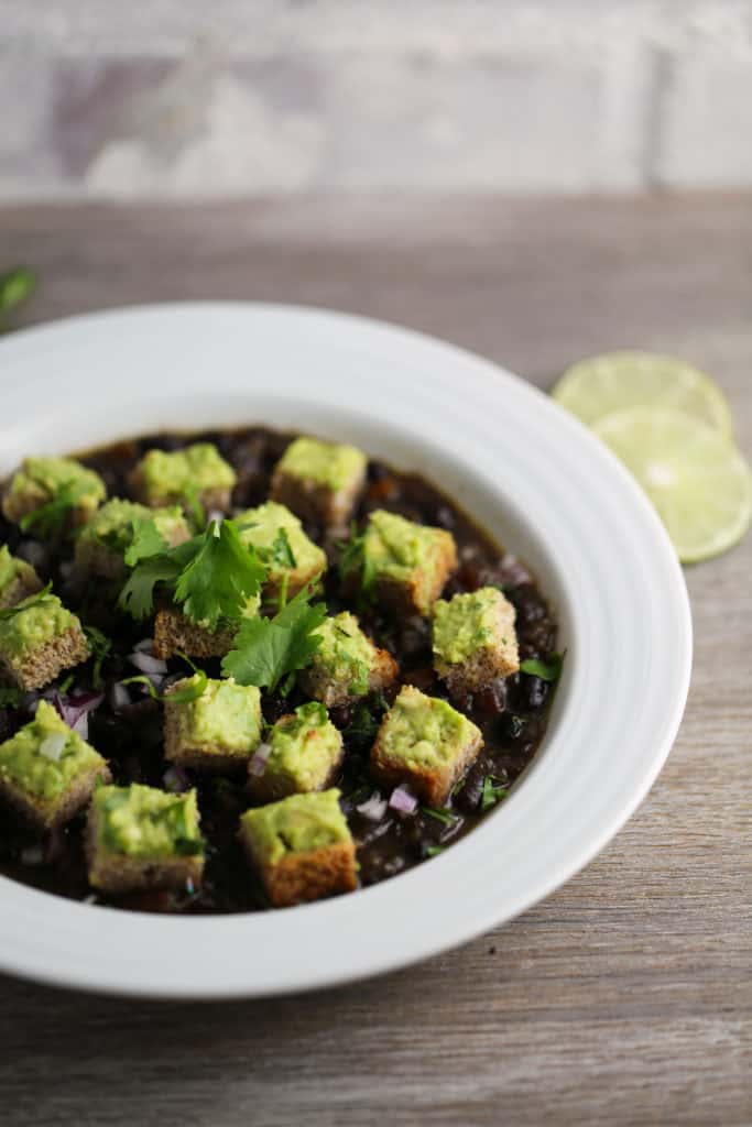 black bean soup with avocado croutons in a bowl.