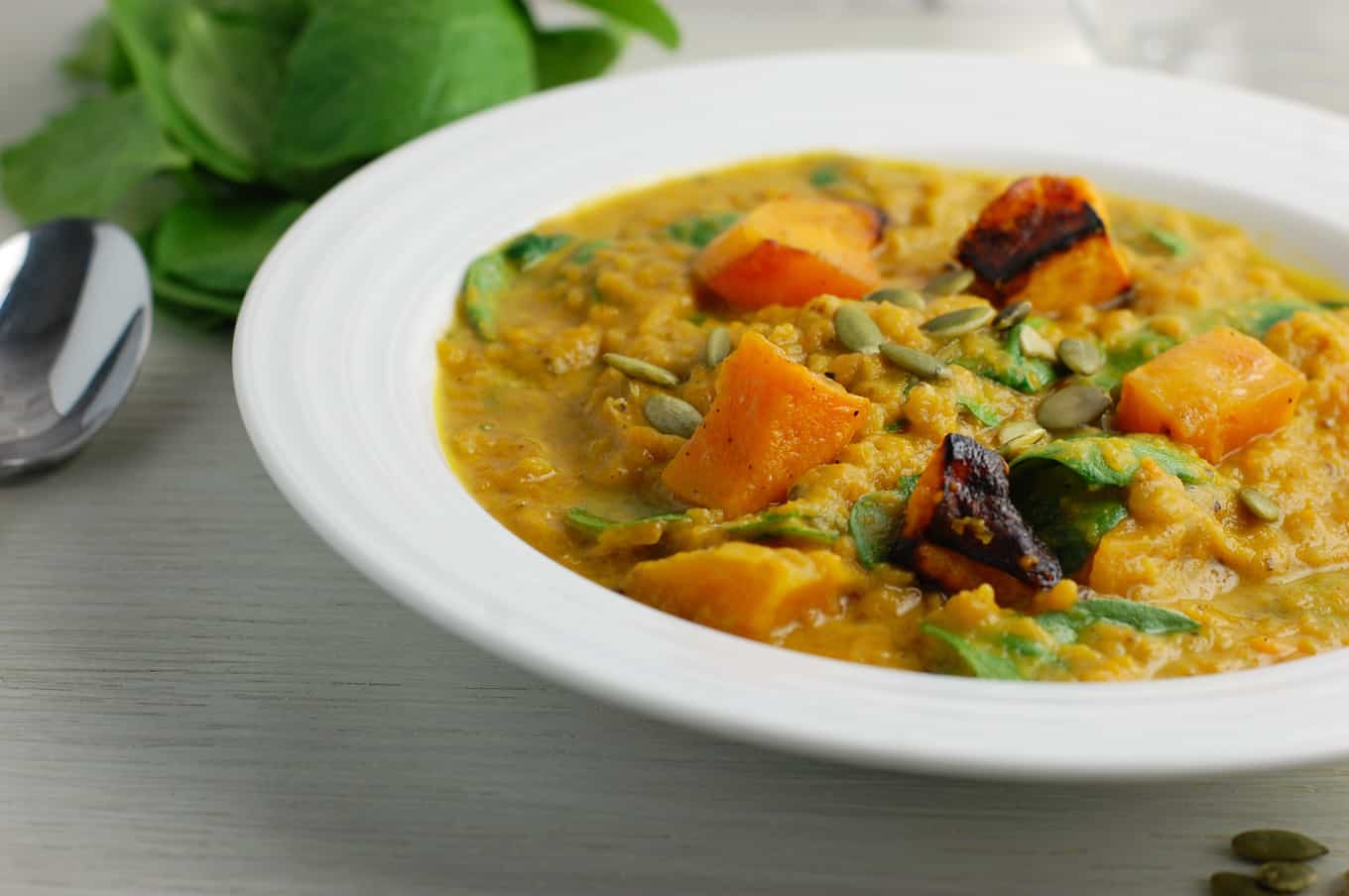 red lentil squash stew with pepitas in a bowl