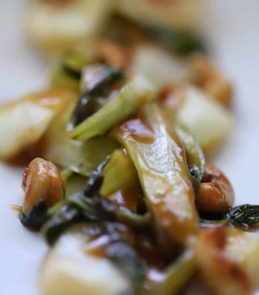 Close up of Chinese garlic sauce on bok choy and cashews