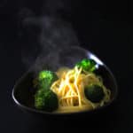 Bowl of spaghetti with broccoli and lemon garlic sauce. Steam from the pasta is seen in the picture