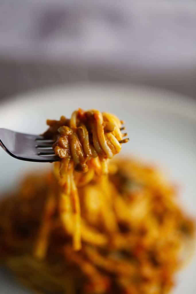 Fork with spaghetti and lentil bolognese sauce.