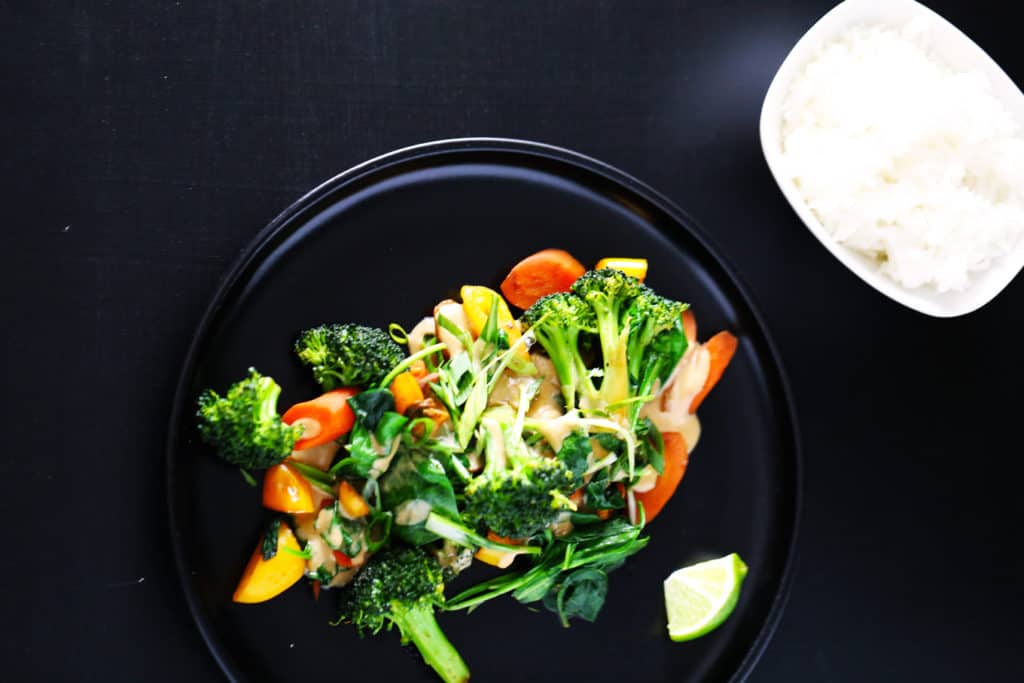 Coconut peanut sauce with stir-fried veggies and rice. Fresh vegetables stir-fried and tossed in a sauce of coconut milk, peanut butter, and spices. Serve with steamed rice for an easy and healthy dinner.