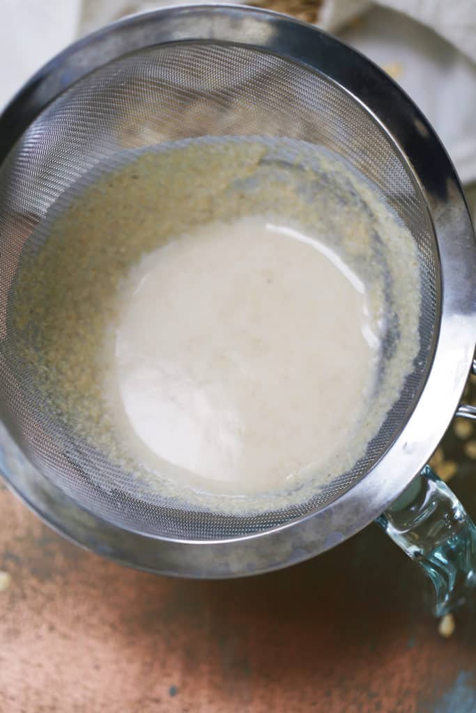 blended oat milk in a sieve.
