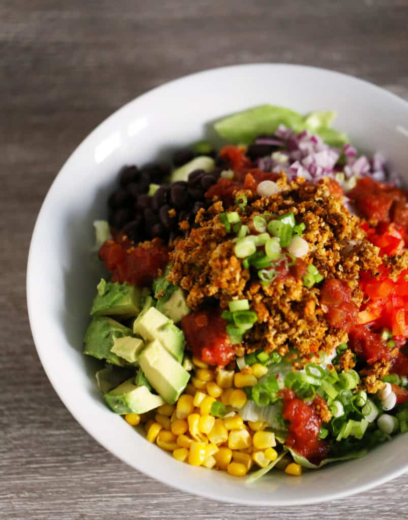 A vegan taco salad bowl, with vegan taco meat and fresh vegetables.