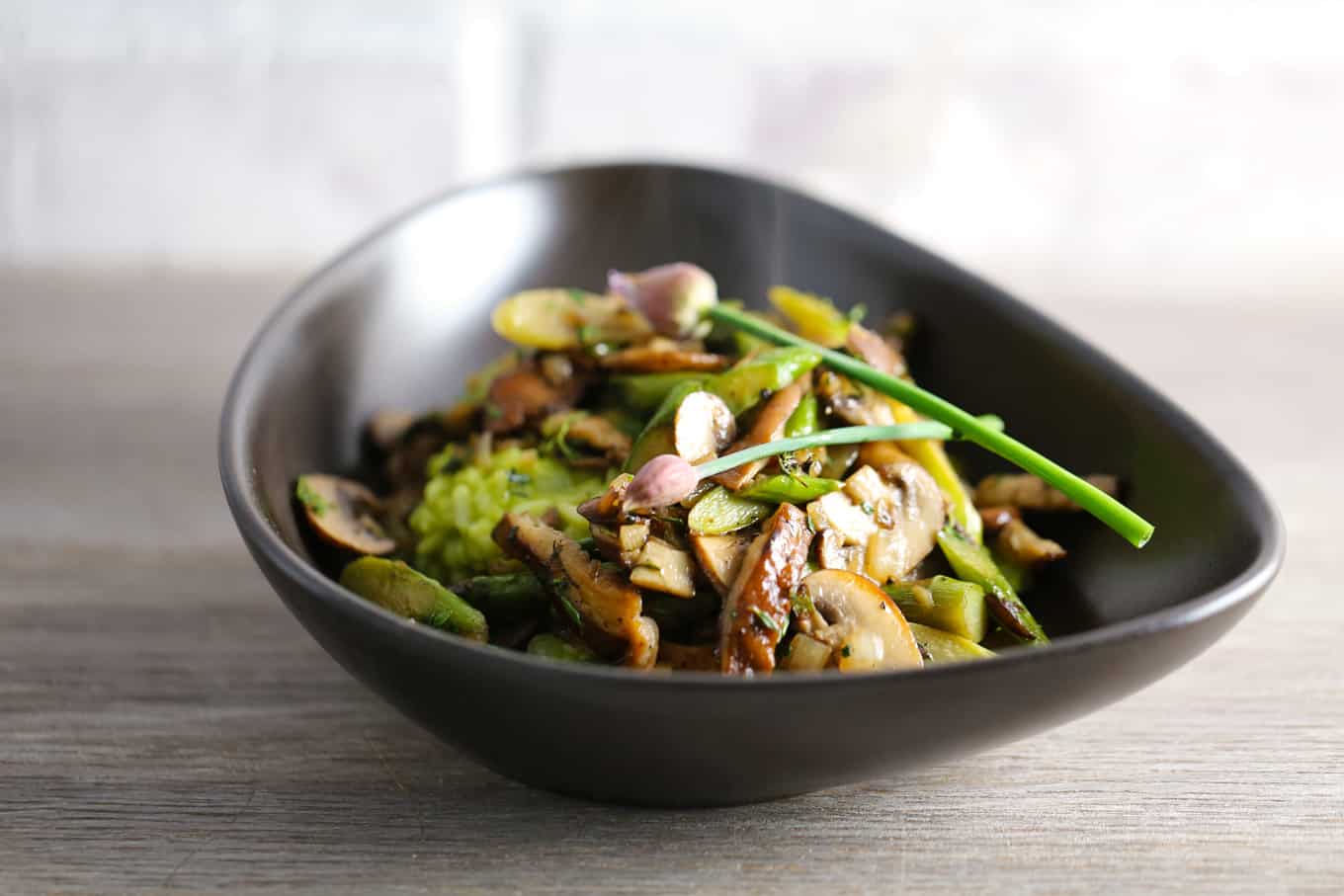 A bowl of asparagus risotto with mushrooms.