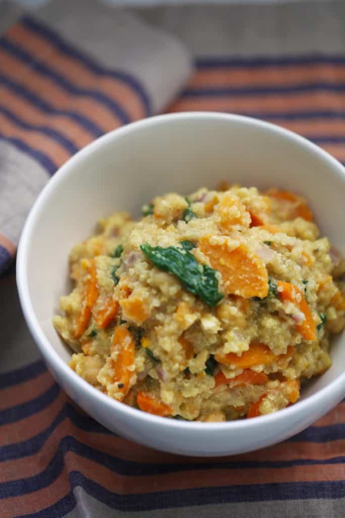 A bowl of quinoa with sweet potato and spinach.