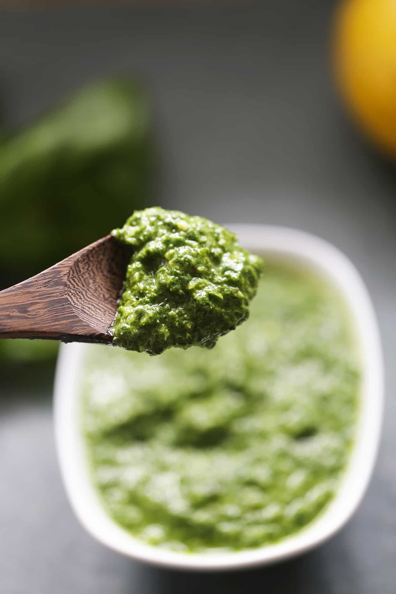 A wooden spoon with nut-free vegan basil pesto on it.